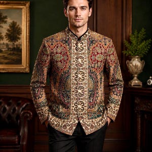 Könnte beinhalten: Eine langärmelige Jacke mit Stehkragen und einem komplexen, mehrfarbigen Paisleuchtigen Paisley-Muster in Rot-, Gold-, Schwarz- und Grüntönen. Die vordere Knopfleiste ist mit einem vertikalen Band aus aufwendigen Stickereien und einer Knopfleiste verziert.