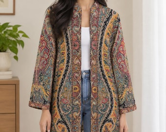 May include: A long-sleeved open-front jacket featuring a vibrant, multi-colored paisley pattern in shades of red, yellow, blue, and black. The garment has a straight silhouette, a mandarin-style collar, and a structured, woven fabric construction.