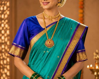 May include: A teal silk saree with a deep blue border and gold zari embroidery, paired with a matching blue blouse. The ensemble is accessorized with a gold necklace featuring a central pendant, gold earrings, and stacks of dark green glass bangles.