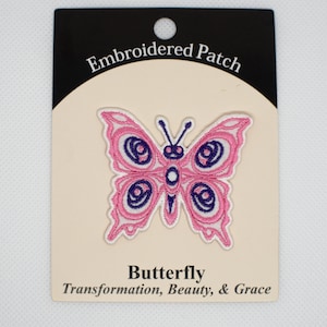 May include: Embroidered patch of a pink butterfly with purple accents. The patch has the text "Butterfly" and "Transformation, Beauty, & Grace" below the image.