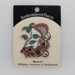 May include: Embroidered patch featuring a brown beaver with green leaves and the text "Beaver Obliging, Generous & Industrious" on a white background.