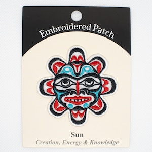 Peut inclure: Patch brodé représentant un visage de soleil stylisé en rouge, blanc, bleu et noir. Le texte "Embroidered Patch" est en haut de la carte et "Sun" est sous l'image. Le texte "Creation, Energy & Knowledge" est en bas de la carte.