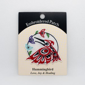 May include: Embroidered patch featuring a stylized hummingbird design in red, black, and white, with accents of blue and green. The patch is on a cream-colored backing with the words "Embroidered Patch" and "Hummingbird" printed on it.