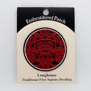 May include: Red and black embroidered patch with a traditional First Nations longhouse design. The patch is circular and has a white border. The text "Embroidered Patch" and "Longhouse Traditional First Nations Dwelling" is printed on the card.