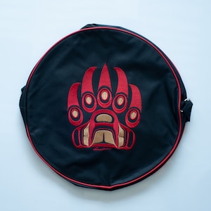 May include: Black canvas bag with a red embroidered bear paw print. The paw print has a gold outline and the text "Haida Gwaii" is embroidered below it.