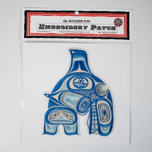 May include: Blue and white embroidered patch featuring a stylized orca whale design. The patch is packaged in a clear plastic bag with a header card that reads "Golden Top Embroidery Patch" and "Made in Canada".