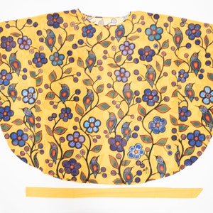 Peut inclure: Un haut jaune, semi-transparent et ample avec un motif floral et d'oiseaux. Le haut a un col rond et des manches courtes. Une ceinture en tissu jaune assortie est incluse.