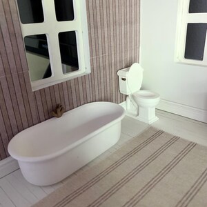 May include: A white bathtub with a brown faucet, a white toilet with a white seat, and a striped rug in a dollhouse bathroom.