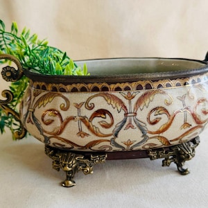 May include: A white ceramic mug with a black handle and the text "But First, Coffee" in a black, bold font. The mug is on a white surface.