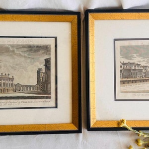 May include: Two framed antique prints of historical buildings in Dublin, Ireland. The left print shows a church with a tall steeple and the right print shows a street scene with buildings lining the street.
