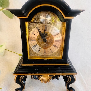 Elgin Bradley Time Division Black and Gold Clock on 4 Legs } Ornate Vintage Roman Numeral Clock Round Face Gold Accents Mantel Gilt Clock }