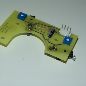 Puede incluir: Una placa de circuito verde con componentes azules y blancos. La placa tiene el texto "HALL EFFECT SENSOR MADE IN USA AC4658-01" impreso en ella.