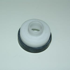 May include: A white plastic component with a cylindrical centre and a dark grey rubber ring base. The object is likely a part of a larger mechanism or device, designed for sealing or support.