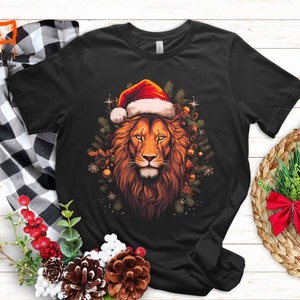 Vorstelijke Kerstmis Leeuw T-shirt | Majestueuze leeuw met kerstmuts T-shirt | Artistieke vakantie dierenkleding | Feestelijke winter unisex top