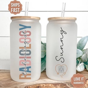 May include: Two frosted glass tumblers with bamboo lids and clear straws. One tumbler has the text "RADIOLOGY technologist" in colorful letters. The other tumbler has the name "Sunny" written on it. Both tumblers have a stethoscope and a heart with an x-ray image inside.