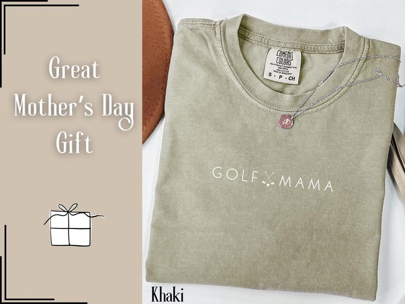 K&ouml;nnte beinhalten: Khaki-farbenes T-Shirt mit dem Text "GOLF X MAMA" in Wei&szlig;. Das Shirt hat einen Used-Look und ist ein tolles Geschenk f&uuml;r einen Golfer.