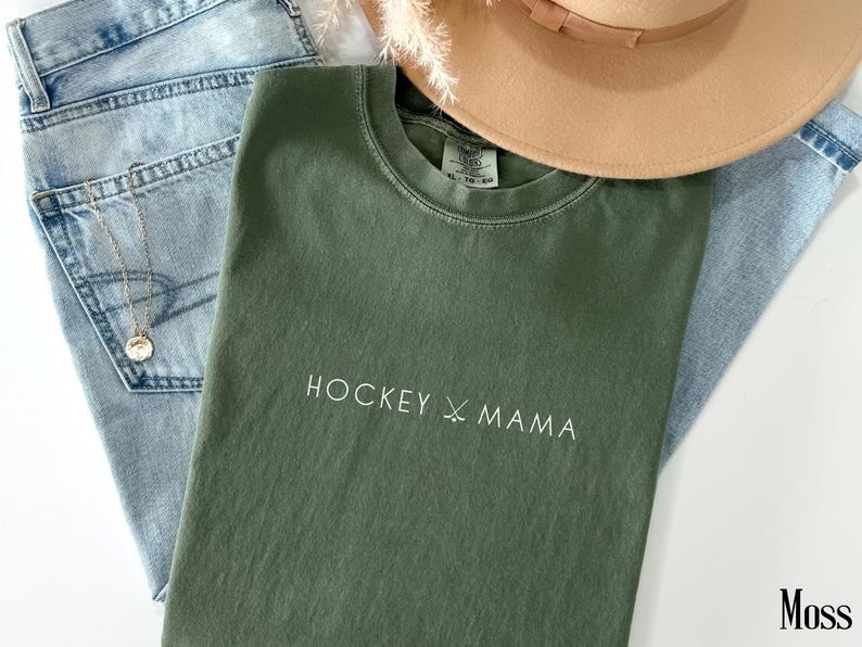 May include: A green t-shirt with the text "HOCKEY X MAMA" in white lettering.