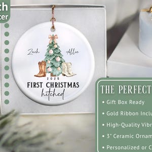 Op de afbeelding: Een witte keramische ornament, 7,6 cm in diameter, met een aquarelontwerp. Het heeft een kerstboom, cowboylaarzen en de tekst "First Christmas Hitched 2025". De namen "Zach" en "Allie" zijn ook opgenomen.