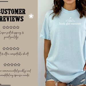 May include: Light blue t-shirt with the text "book girl summer" in white. The shirt has a relaxed fit and short sleeves. The image also shows customer reviews.