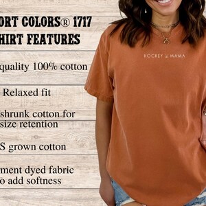 May include: A rust-colored t-shirt with the text "HOCKEY MAMA" printed on the front. The t-shirt is made of 100% cotton and has a relaxed fit.