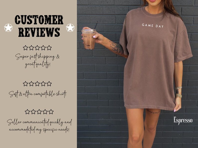 May include: A brown oversized t-shirt with the text "GAME DAY" printed on the front. The shirt is being worn by a person with tattoos on their arm. The background is a brick wall.