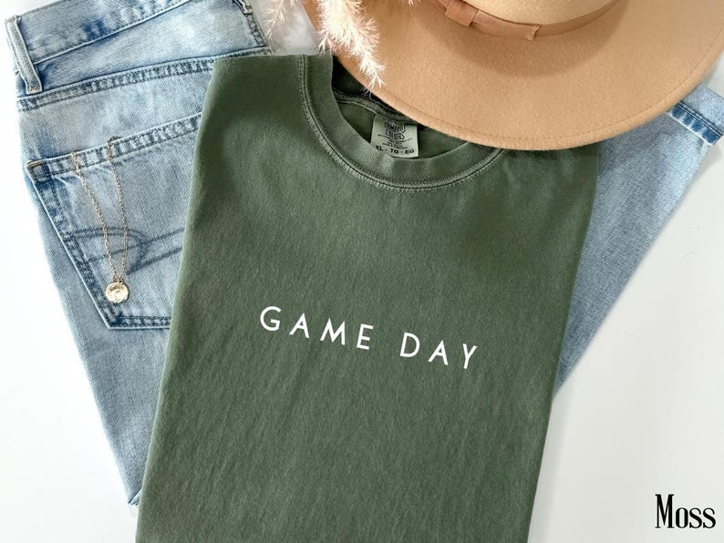 May include: A green t-shirt with the text "GAME DAY" in white lettering.