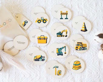 May include: A set of 12 wooden construction themed play pieces. Each piece is a circle with a different construction vehicle or tool on it. The pieces are in a white drawstring bag with the words "Playwood Treasures" printed on it.