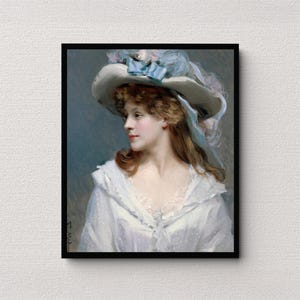 May include: A framed portrait of a woman in a white dress and hat. The woman has long auburn hair and is wearing a wide-brimmed hat adorned with blue ribbons and feathers. The dress has a ruffled neckline and a delicate, dotted pattern.