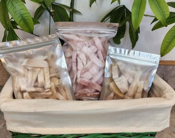 May include: Three clear plastic bags filled with dried fruit slices. The bags are sitting in a woven basket.
