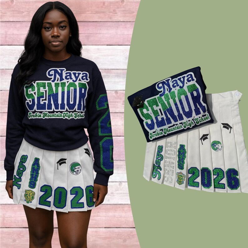 May include: Navy blue sweatshirt and white pleated skirt with green and blue accents. The sweatshirt says "Naya SENIOR Arabia Mountain High School" and the skirt says "2026" with graduation-themed patches. A matching patch is also shown.