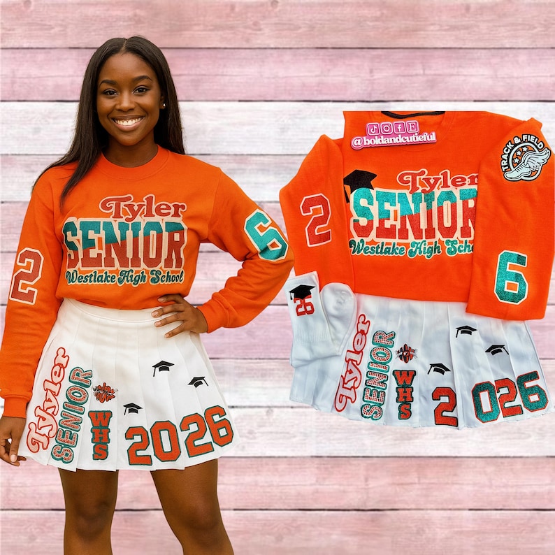 May include: Orange sweatshirt and white pleated skirt with "Tyler SENIOR Westlake High School" text and "2026" on them. The sweatshirt has the number "2" on the left sleeve and "6" on the right sleeve. A matching set.