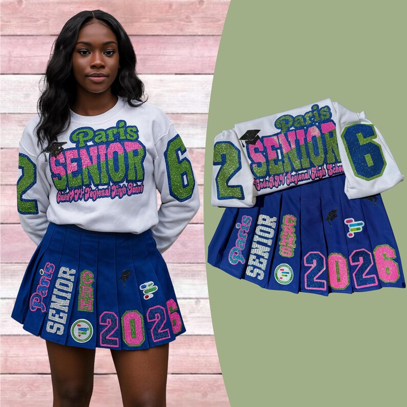 May include: A white sweatshirt and a blue pleated skirt with the text "Paris SENIOR 2026". The sweatshirt has green and pink glitter accents. The skirt has matching glitter details.