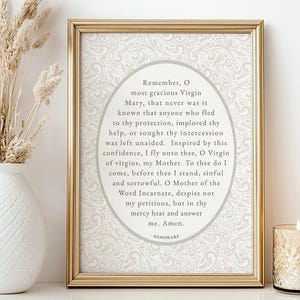Elegant framed Memorare Prayer printable wall art displayed on a neutral table with a white vase of dried florals and a lit candle — Catholic digital download print in vintage cream tones, perfect for prayer corner or home altar decor.