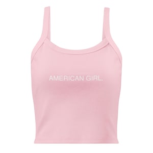 May include: A light pink tank top with thin straps. The text "AMERICAN GIRL." is printed in white across the front. The top is made of a soft, likely cotton, material.