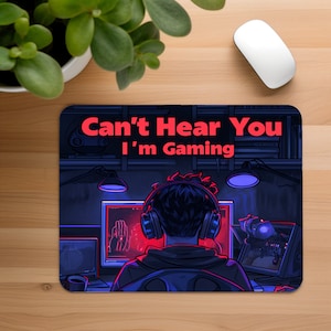 May include: A black and blue gaming mouse pad with a gamer wearing headphones and the text "Can't Hear You I'm Gaming" in red.