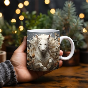 May include: White ceramic mug with a graphic of a white horse with a flowing mane and tail, surrounded by white flowers and leaves. The horse is running towards the viewer.