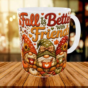 May include: A white ceramic mug featuring a colorful illustration of three gnomes with sunflowers and pumpkins. The text "Fall Is Better With Friends" is printed in large, decorative orange and red lettering across the top of the mug surface.