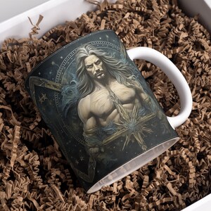 May include: A white ceramic mug with a black and blue design featuring a man with long white hair and a beard. The design includes stars and a large starburst.