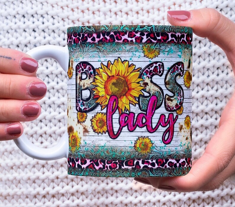 May include: White ceramic mug with a colorful design featuring a sunflower, leopard print, and the text "Boss Lady".