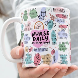 Pode incluir: Caneca de cerâmica branca com um design colorido que inclui as palavras "Nurse Daily Affirmations". A caneca tem uma variedade de afirmações positivas para enfermeiras, incluindo "Sou um solucionador de problemas", "Sou gentil com minha mente" e "Sou suficiente".