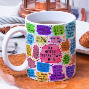 May include: White ceramic mug with a colourful design featuring the text "My Mental Breakdown Mug" and various phrases about mental health, including "It's okay to feel bad", "It's okay to have hard days", and "There is nothing wrong with feeling your emotions".