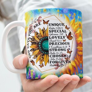 May include: White ceramic mug with a colorful design featuring a sunflower, butterflies, and the text "God says you are Unique, Special, Lovely, Precious, Strong, Chosen, Forgiven" with corresponding Bible verses.