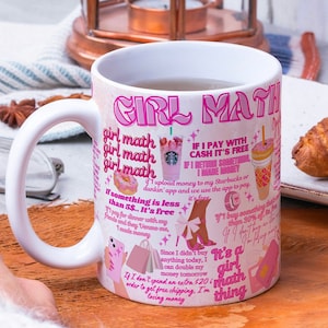 Può includere: Tazza in ceramica bianca con la scritta "GIRL MATH" in rosa, insieme a varie frasi e illustrazioni relative alle abitudini di spesa. La tazza ha un manico grande ed è decorata con immagini di bevande al caffè, borse della spesa e scarpe.