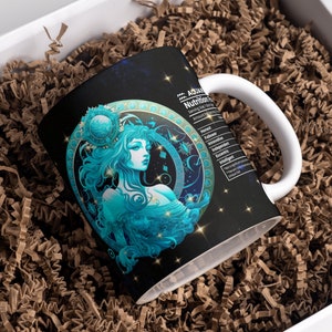 May include: A white ceramic mug with a black background and a blue and gold illustration of the astrological sign Aquarius. The mug has a white handle and the text "Aquarius Nutrition Facts" is printed on the side.