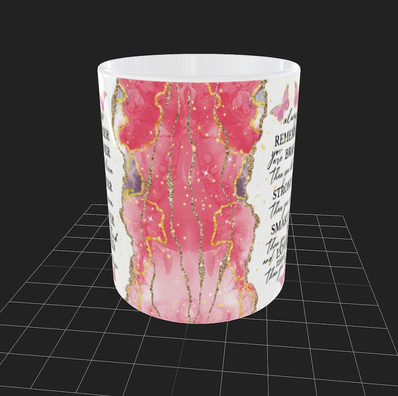 May include: White ceramic mug with a pink and gold glitter design. The mug has a quote that reads "Remember you are braver than you think, stronger than you seem, smarter than you feel, and loved more than you know."