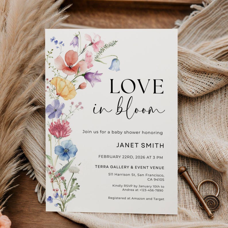 May include: A baby shower invitation with the words "LOVE in bloom" in black script. The invitation features a watercolor floral design in pink, purple, yellow, and blue. Details include the honoree's name, date, time, and venue.