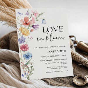 May include: A baby shower invitation with the text "LOVE in bloom" and floral watercolor illustrations in pink, orange, yellow, blue, and purple. The invitation includes event details for Janet Smith.