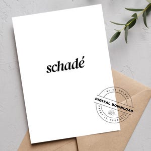 Könnte beinhalten: Weiße Karte mit dem Wort "schadé" in schwarzer Schrift. Die Karte liegt auf einem braunen Umschlag. Ein runder Stempel lautet "Digitaler Download" und "Drucken Sie es selbst". Grünzeug ist im Hintergrund.
