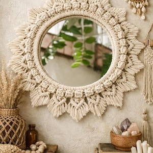 以下が含まれることがあります： クリーム色のマクラメの丸い鏡、サンバーストのデザイン。鏡は織り模様で囲まれ、自然なボヘミアンスタイルの美学を持っています。装飾要素には、織りの花瓶、木製のビーズ、三日月型の壁掛けが含まれます。