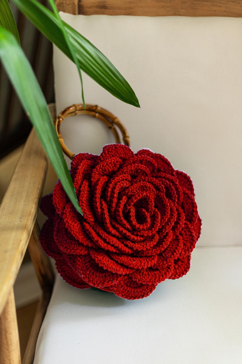 May include: A red crocheted rose-shaped bag with a bamboo handle.